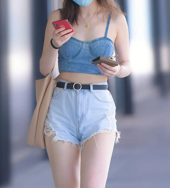 一件白色的背心，搭配了一件浅蓝色的长袖外套，下半身穿着一件白色的休闲裤，凉鞋，包包等。